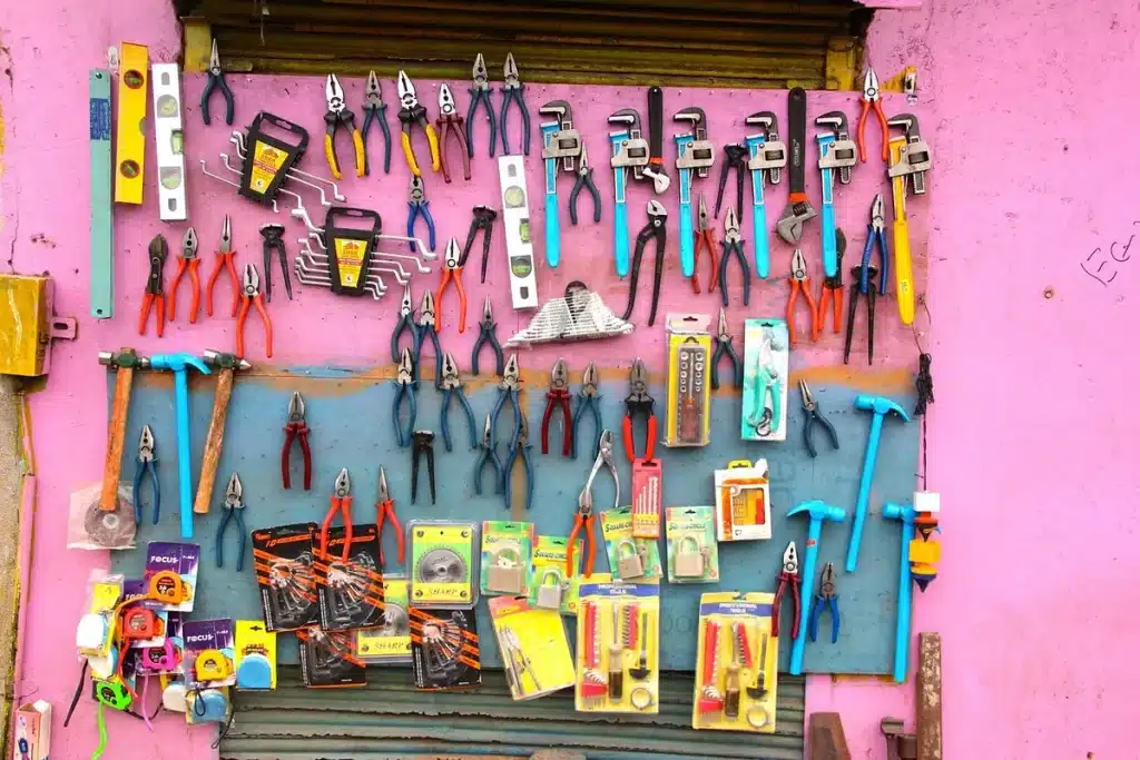 Plan de travail en journée avec outils et une feuille de cuivre tenue par des mains anonymes