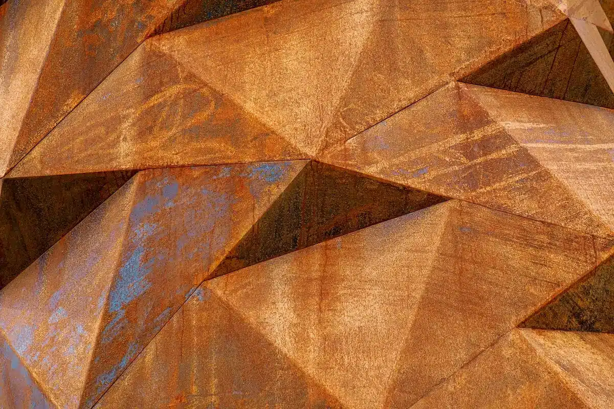 Gros plan sur la texture métallique d'une plaque d'acier montrant nuances de gris