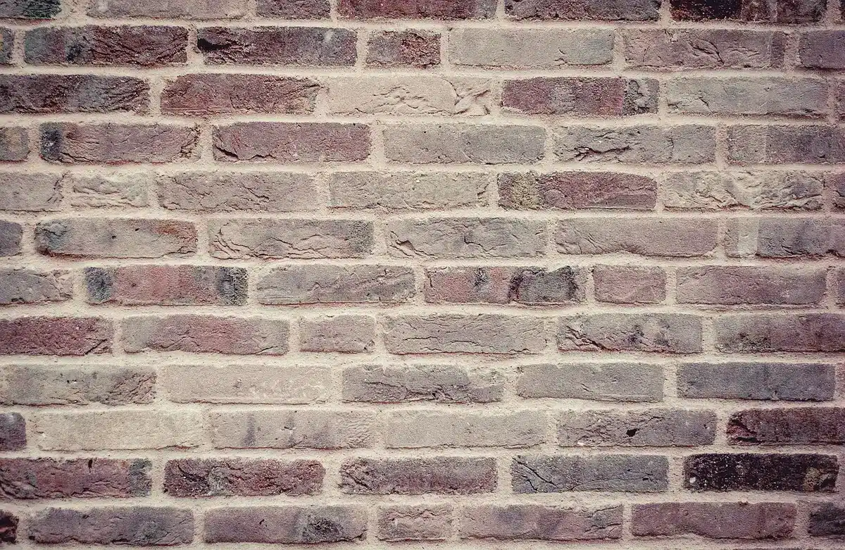 Artisans compactant un mur en pisé avec coffrage en bois